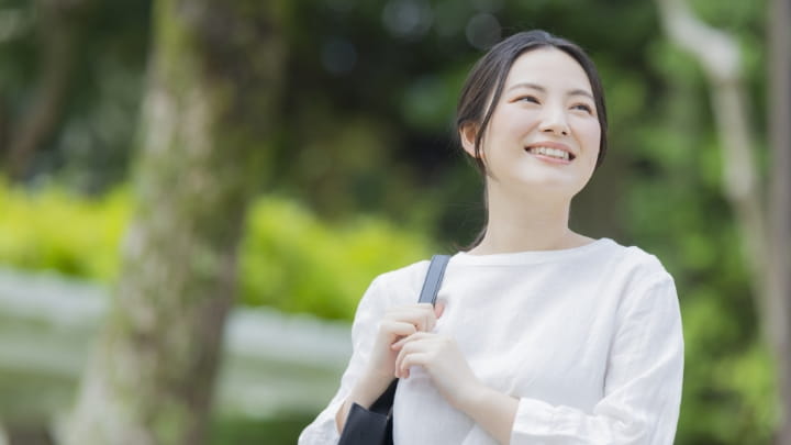 豊かな屋外を笑顔で歩く女性スタッフ